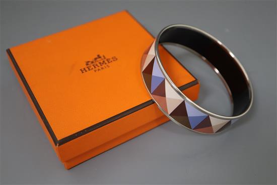 A Hermes, Paris enamelled bangle with geometric pattern, with pouch and box.